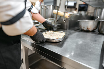 Chef cooking food at restaurant kitchen close up