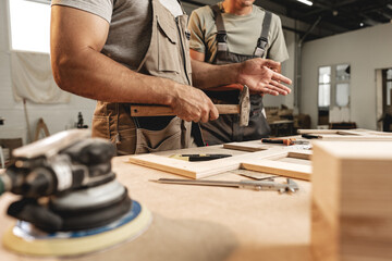Two carpenters working together at a workshop