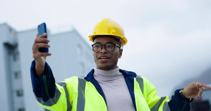 Video call, pointing and engineering with black man in city for social media, architecture and project management. Smile, mobile and hello with contractor on construction site for communication app