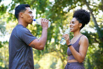 Fitness team cools down after exercise in park, beautiful couple drinking water