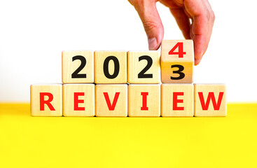 2024 review new year symbol. Businessman turns a wooden cube and changes words Review 2023 to...