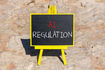 AI regulation symbol. Concept words AI artificial intelligence regulation on blackboard. Beautiful...