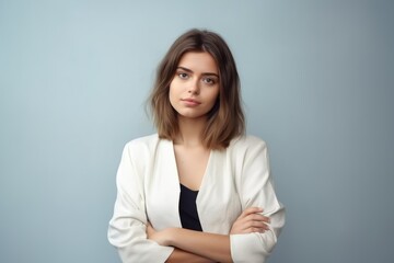 Fototapeta premium Portrait of an elegant fictional young woman with short hair wearing casual clothes. Isolated on a plain light blue background. Generative AI.