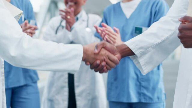 Doctor, handshake and people applause in teamwork, meeting or partnership together at the hospital. Closeup of medical or healthcare professional shaking hands and clapping in celebration or success