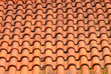 Old roof tiled with S-shaped clay tiles. Photo in perspective with selective focus
