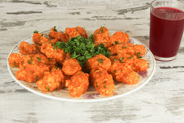 Potato dumplings in white plate with cold red drink on table. Sitting view. Vegan and healthy food concept idea. Potato dumpling known as 'patatesli bulgur kofte' in Hatay, Turkiye. 