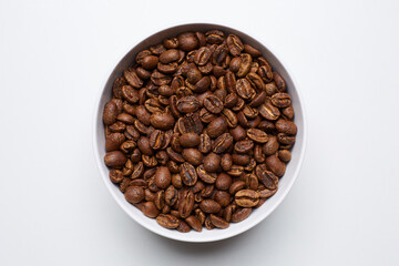 roased coffee beans in bowl on white background. Still Photo