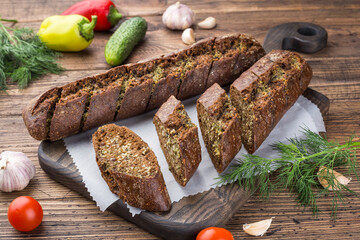 garlic rye baguette roll on a wooden cutting board