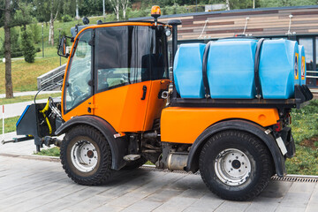 Fototapeta premium small tank truck for cleaning paths and watering plants in the city park