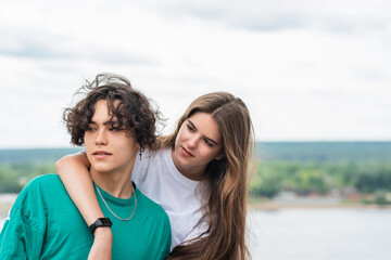 Obraz premium couple of young people hugging against a blurred river landscape