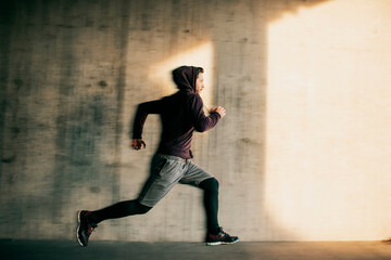 Young man running and exercising in a tunnel in the city