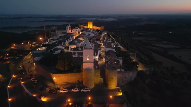 Aerial footage of the Monsaraz Castle on a hill at night, Portugal