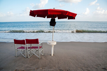 Parasol with foldout chairs against the horizon on the foreshore at dusk. Lifeguard post at the end of the working day.