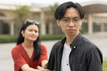 An upset or manipulative boyfriend, looking at the camera, leaving his remorseful and desperate...