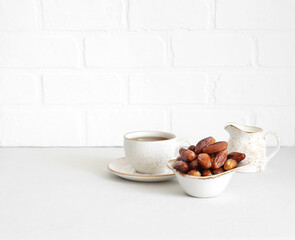 Dried dates and a cup of tea on white background. Copy space. Healthy breakfast concept.