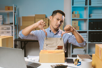 Fototapeta premium Asian male small business owner using mobile app on smartphone checking parcel box. Warehouse worker, seller holding phone scanning retail dropshipping package postal parcel bar code.