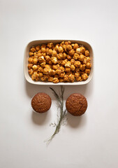 Chocolate cupcakes and caramel popcorn on a white background flat lay