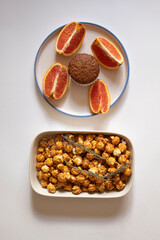 Chocolate cupcakes in a plate with sliced oranges and caramel popcorn