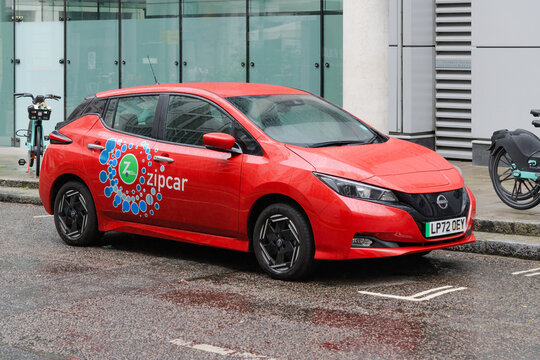 London, UK - July 30, 2023; Red Zipcar with brand logo parked on wet City of London street