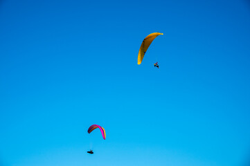 View of twin para gliders swinging under blue skyline at Peak district UK