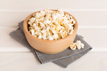 Popcorn in bowl on wooden table
