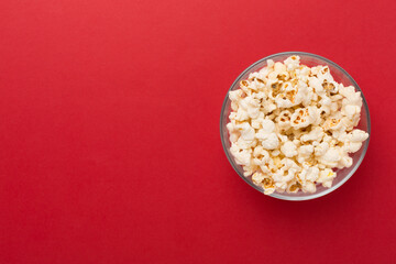 Tasty popcorn in bowl on color background