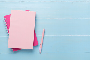 Notebooks with stationery on wooden background, top view