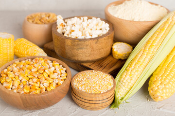 Maize products with fresh corn cobs on wooden table