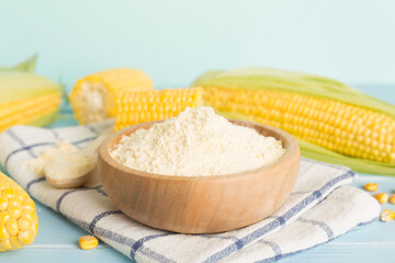 Corn flour with fresh cobs on wooden table