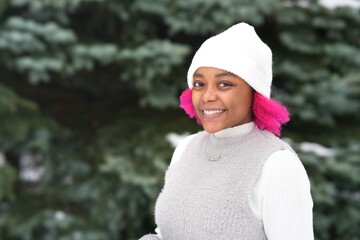 Portrait of happy black Afro American young woman at winter snowy day in snow park smile 