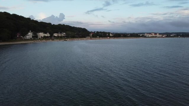 Aerial drone view - Beach in the Baltic resort of Binz shortly after sunrise, the Kurhaus Binz, pier, Ruegen Germany, Europe