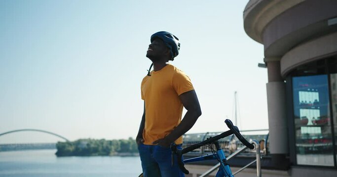 African American guy in helmet types message on smartphone