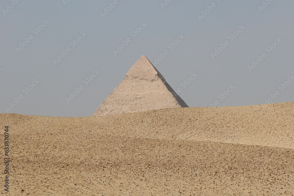 Wall mural The three pyramids of Egypt side by side in the middle of desert sand with the sky in the background