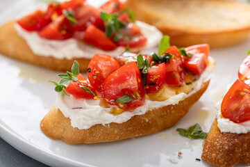 Fototapeta na wymiar Tomato basil and cream cheese bruschettas with fresh cherry tomatoes