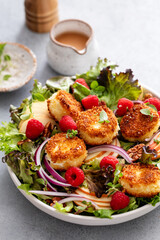 Fried goat cheese salad with apples and raspberries and vinaigrette dressing