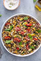 Warm quinoa salad with tomatoes, corn and zucchini