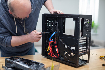 IT specialist removes various parts from computer with screwdriver