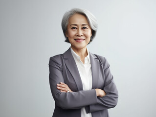 Portrait of a Smiling Asian Business Woman middle age 50s 40s arms crossed isolated white background
