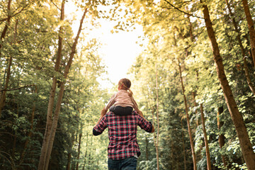 Naklejka na ściany i meble Family time adventure father and daughter child enjoying a nature walk hike in the forest. 