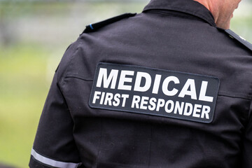 A close-up of a Caucasian male emergency health medical first responder or paramedic wearing a...