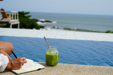 Green smoothie and journaling by the pool tropical vibes summer mindfulness