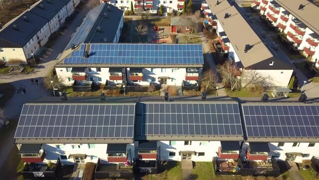 Aerial view of swedish apartment building covered with solar photovoltaic panels in Linkoping residential area. Renewable electricity development