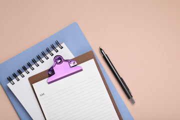 Mini clipboard with to do notes, planner, notebook and pen on beige background, flat lay. Space for text