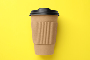 One paper cup on yellow background, top view. Coffee to go