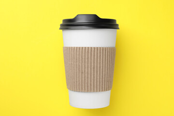 One paper cup on yellow background, top view. Coffee to go