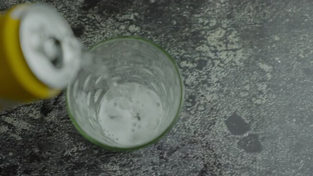A glass with being filled with carbonated soft drink, you can see the fresh bubbles of the beverage. White Soda lemon Derives From The can pouring to a glass. Pouring Soda. Slow motion B roll 4k.