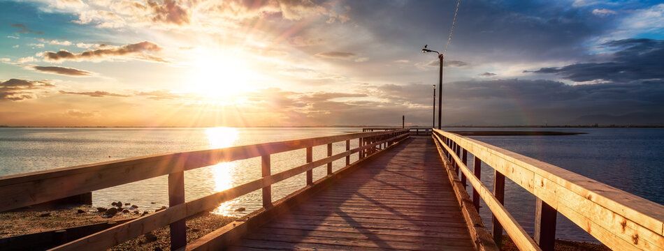 Wooden Quay at Rocky shore on Pacific Ocean West Coast. Sunset.