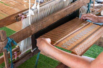The traditional weaving of handmade cotton on the manual wood loom in Thailand.