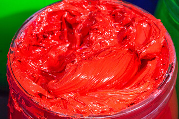 close up red color of ink for print tee shirt..the red paint in the glass bucket.the red of plastisol ink for print tee shirt in the transparent glass bucket. .colorful of red ink background.