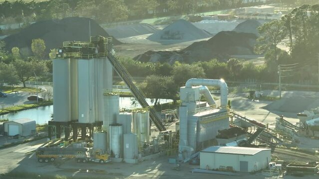 Concrete manufactory at cement mixing factory. Industrial area with cargo trucks and heavy building equipment